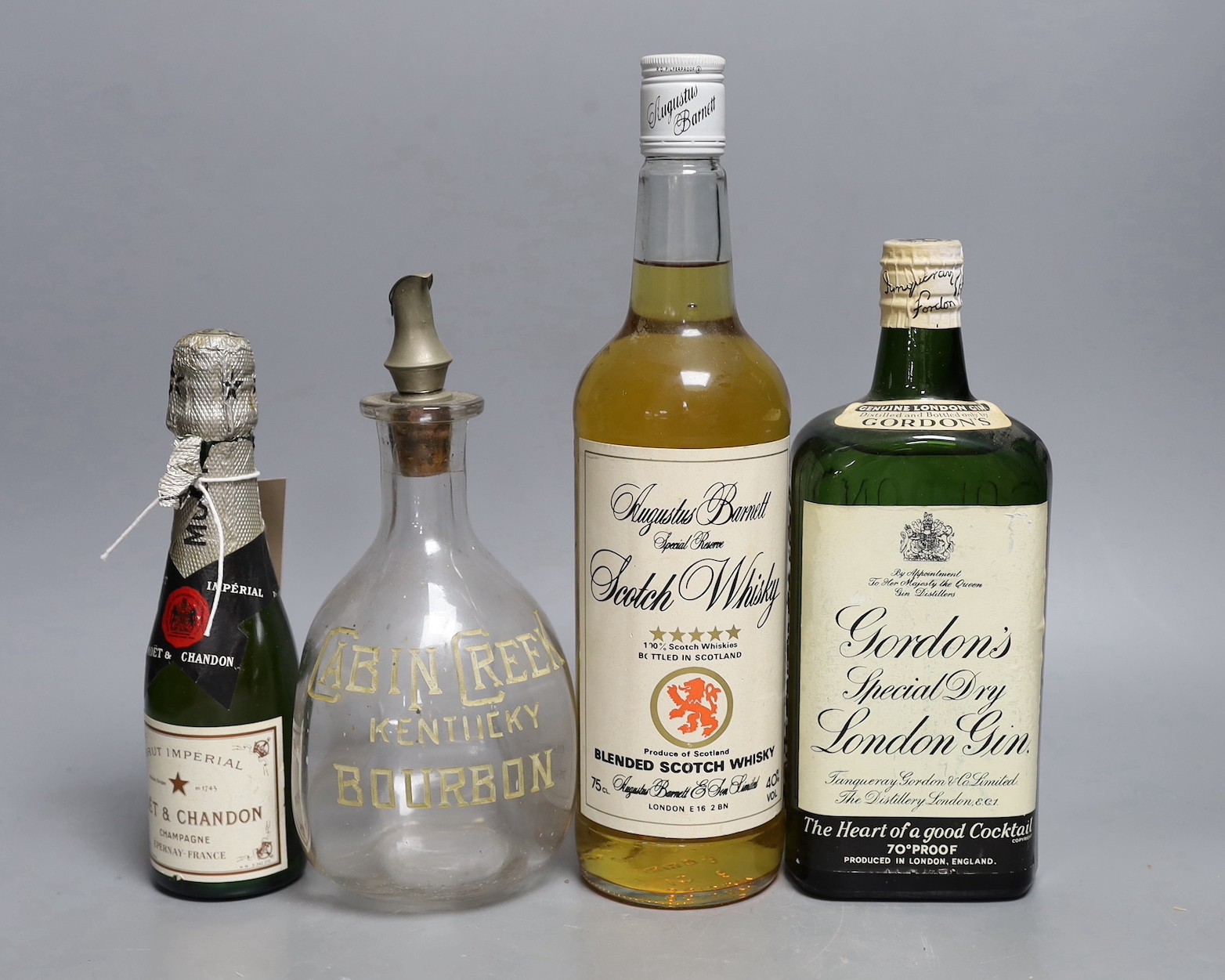 A bottle of (approx 70cl) Gordon's Special Dry London Gin, a bottle of 75cl Augustus Barnett Special Reserve Scotch Whisky, a bottle of 20cl Moët & Chandon Brut champagne, and a ewer (4)